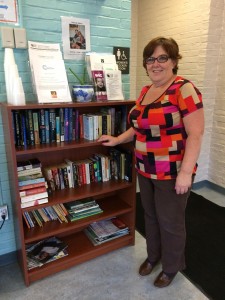 Corrine Keane, building manager of the BCYF Flaherty Pool, standing in front of the community bookcase